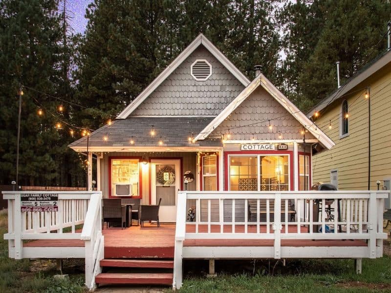 Quaint cottage with warm string lights and a welcoming porch in Big Bear, CA.