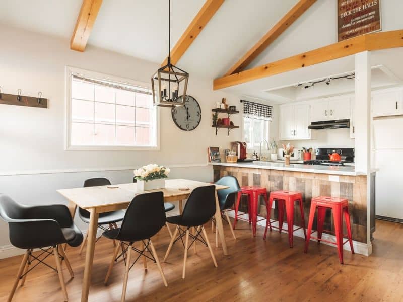 Bright kitchen and dining area with wooden accents and red bar stools in one of the best family cabins near Snow Summit in Big Bear.