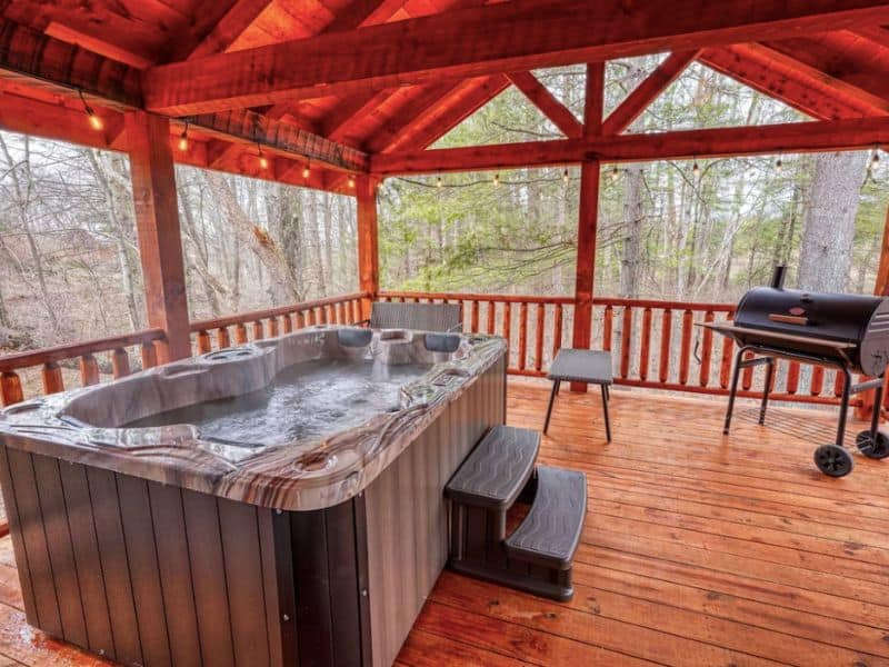 Covered back deck with a hot tub at a vrbo cabin rental for 2 in Hocking Hills, Ohio.
