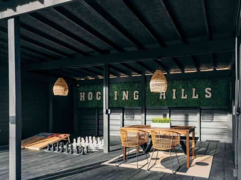 Covered patio of a Hocking Hills cabin rental featuring a chess set and dining area.