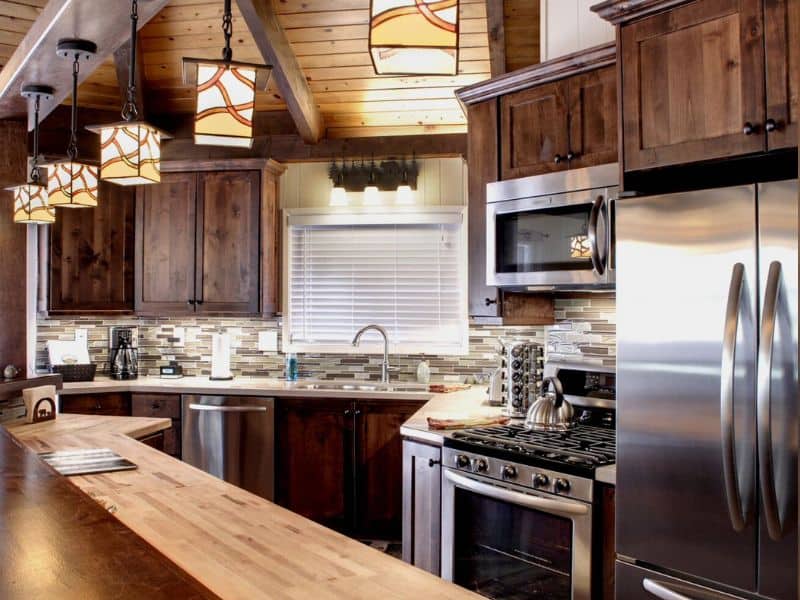 Modern rustic kitchen with pendant lighting, dark wood cabinets, and a subway tile backsplash in one of the best cabin rentals near Snow Summit in Big Bear, CA.