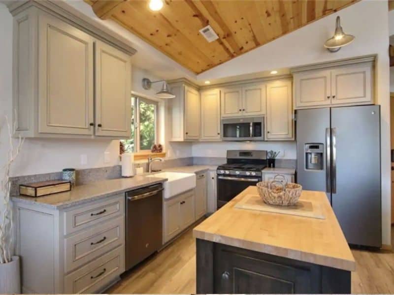 Modern kitchen in a Big Bear CA cabin rental with white cabinetry, stainless steel appliances, and a central island.