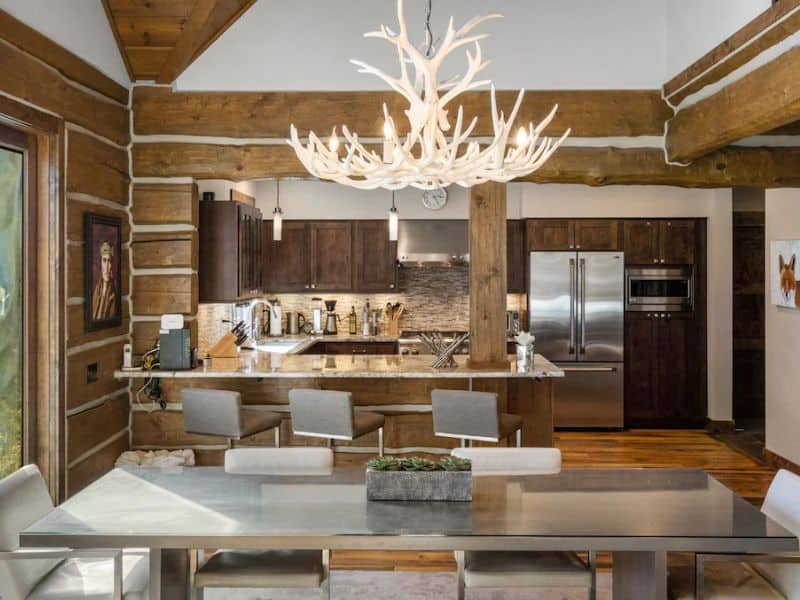 Open-plan kitchen with a modern design and a central dining area in a ski in ski out Big Sky Montana cabin rental.