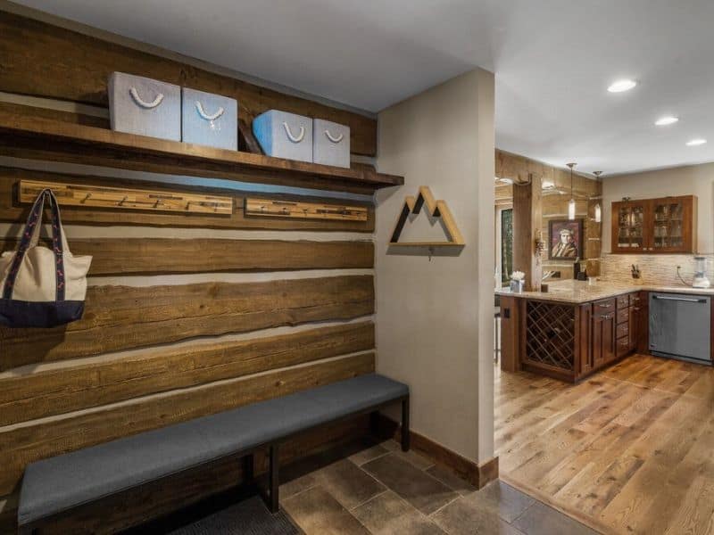 Functional entryway with bench seating and storage for ski gear in a Big Sky rental, ensuring a convenient transition from slopes to comfort.