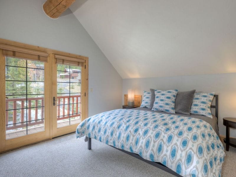 Airy bedroom with balcony access in a Big Sky Montana vrbo.
