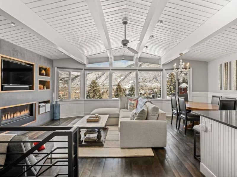 A living room in Aspen, CO with a fireplace and mountain views.