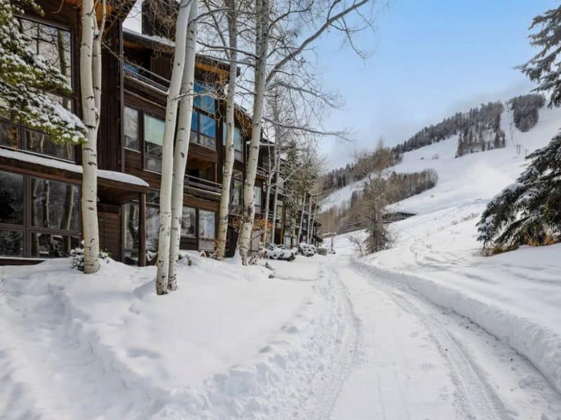 A snow covered road leading to a slopeside condo complex in Aspen, CO.