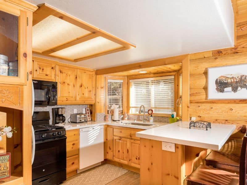 Well-equipped kitchen with natural wood cabinetry and ample lighting in cabin rental near Snow Summit in Big Bear