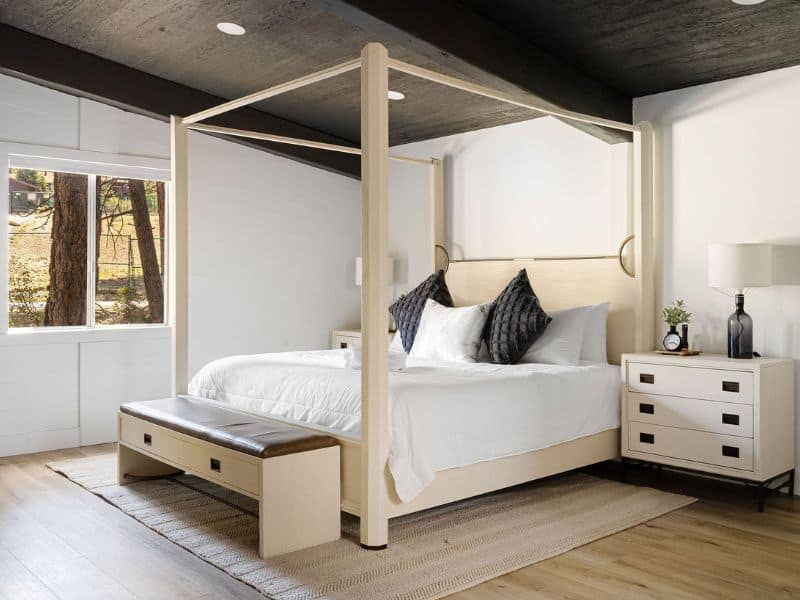 Chic bedroom with a four-poster bed and natural light, in one the best cabin rentals near Snow Summit in Big Bear.