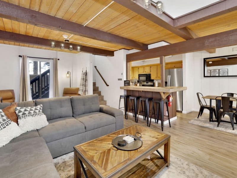 Open-plan living area with a modern kitchen and comfortable seating, one of the best cabins near Snow Summit.