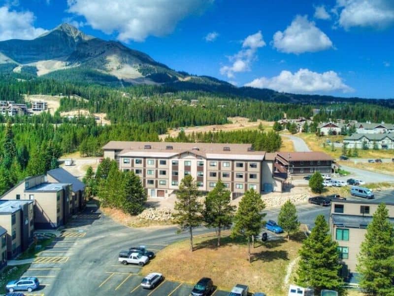 An aerial view of a condo complex nestled amidst the mountains of Big Sky, Montana.