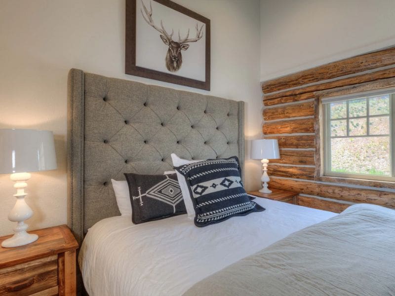 Rustic bedroom with a tufted headboard and cabin-style decor in a Big Sky vacation rental on Vrbo.