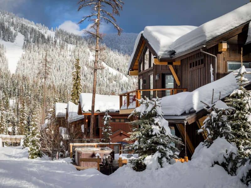 A ski in ski out lodge rental with snow covered trees in the background.