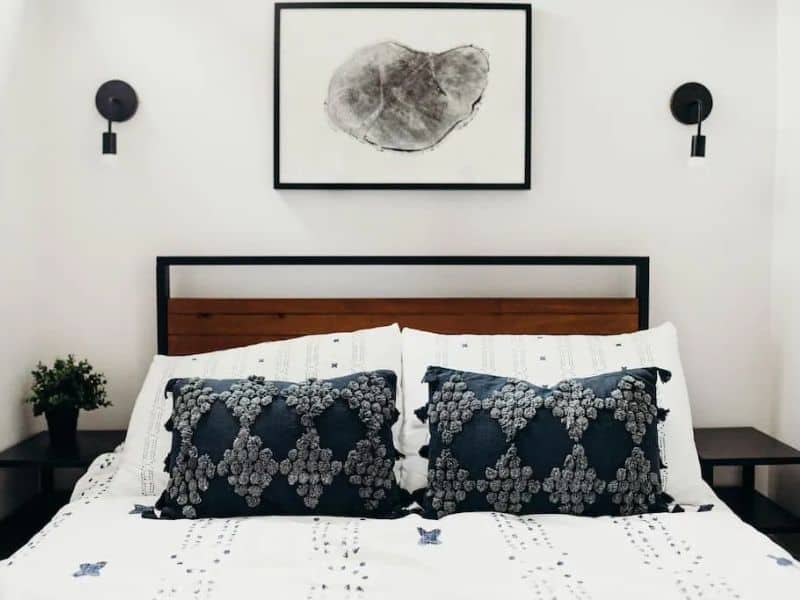 A white bed with black pillows in a container bedroom.
