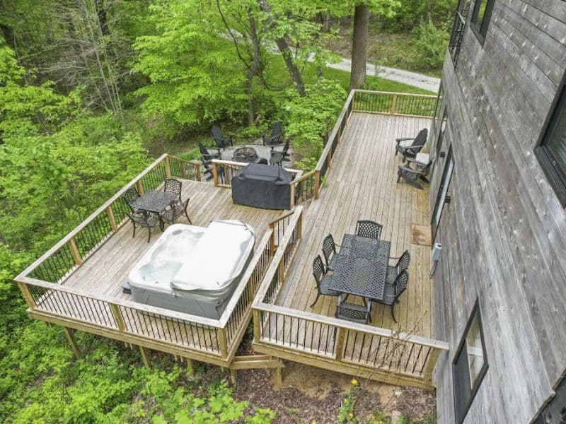 An aerial view of a hot tub on a deck surrounded by woods.