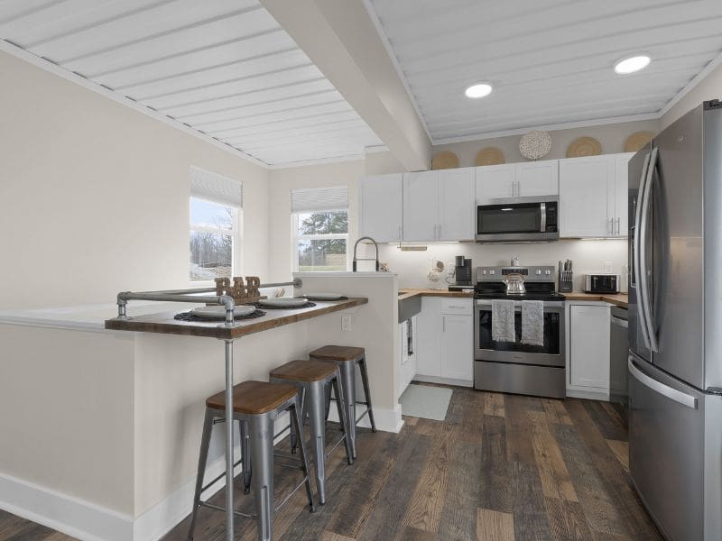 A container cabin in Hocking Hills with stainless steel appliances and wood floors.