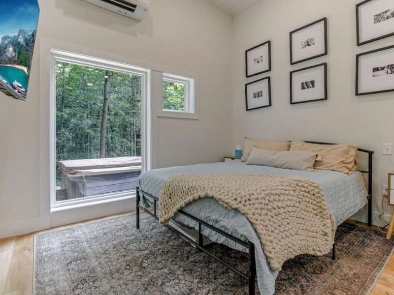 Simple yet stylish bedroom in The Nook with a bed with nature-inspired art on the walls, providing a comfortable stay in Hocking Hills.