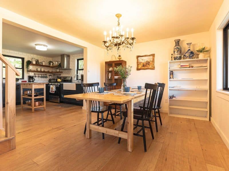 Spacious kitchen and dining area with a rustic wooden table, open shelving, and a warm ambiance in a cozy Catskills cabin rental.