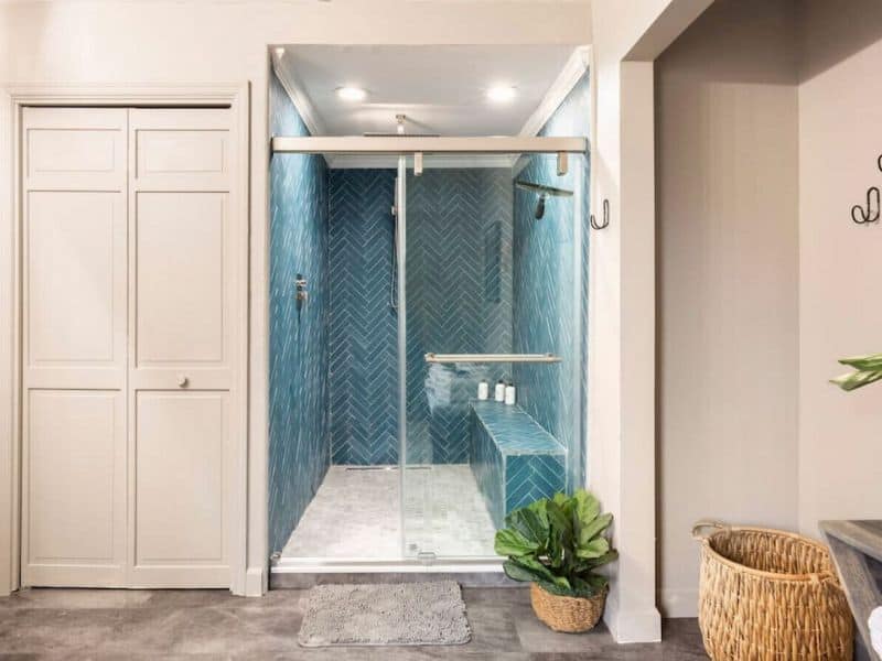 Modern bathroom with a herringbone pattern tiled walk-in shower, reflecting a tasteful touch in cozy Catskills cabin rental.