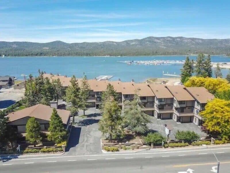 Aerial view of a row of lakefront condo rentals in Big Bear, highlighting their proximity to the lake and the surrounding mountainous landscape.
