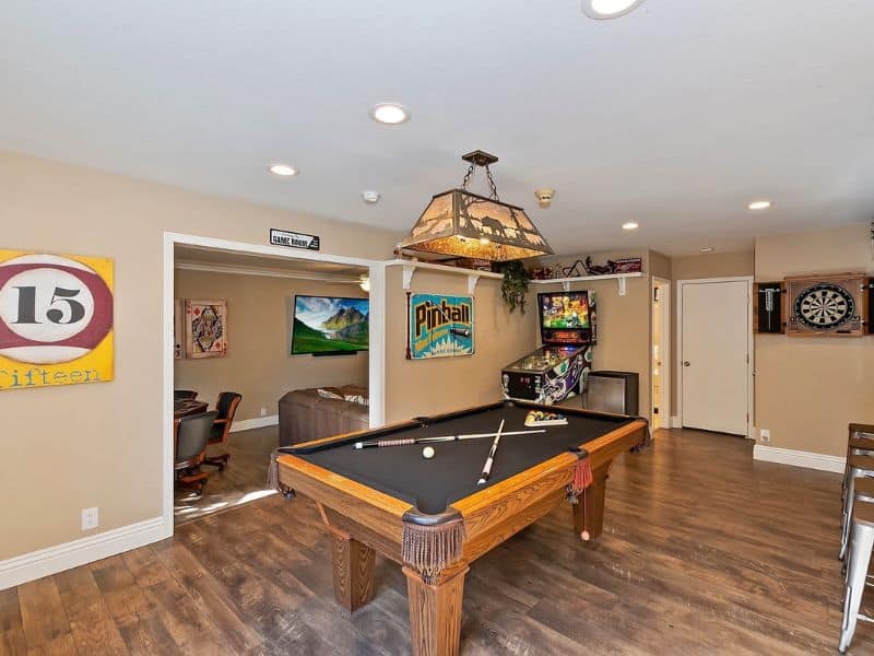Game room in a Big Bear cabin on the lake with a classic pool table, pinball machine, and a dartboard.