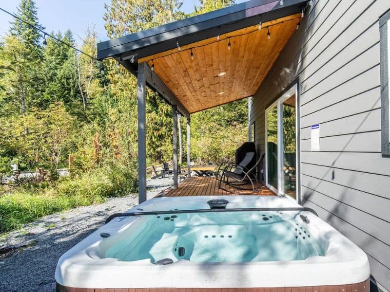 Private hot tub on the deck of a cabin near Mount Rainier amidst forest surroundings.
