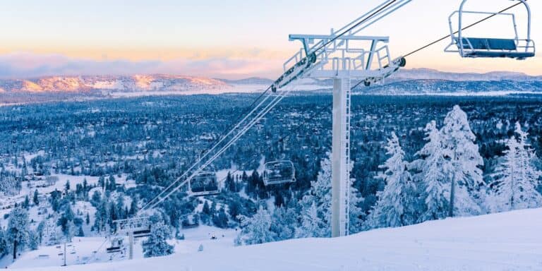 Ski lifts in Big Bear california at dawn with snow covered background.