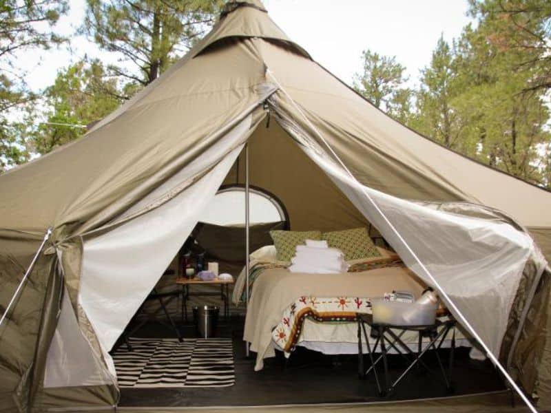The Entrance of an Arizona Luxury Expeditions tent near the Grand Canyon with a comfortable bed and camping amenities.