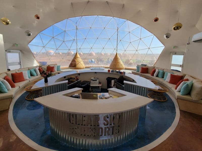 The interior of Clear Sky Resorts - Grand Canyon's lobby with a modern circular reception area and expansive views of the outdoors. Glamping near the Grand Canyon South Rim.