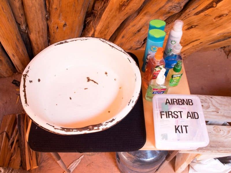 Basic amenities inside a Navajo hogan including a basic washbasin and first aid supplies. Authentic glamping near the Grand Canyon South Rim.