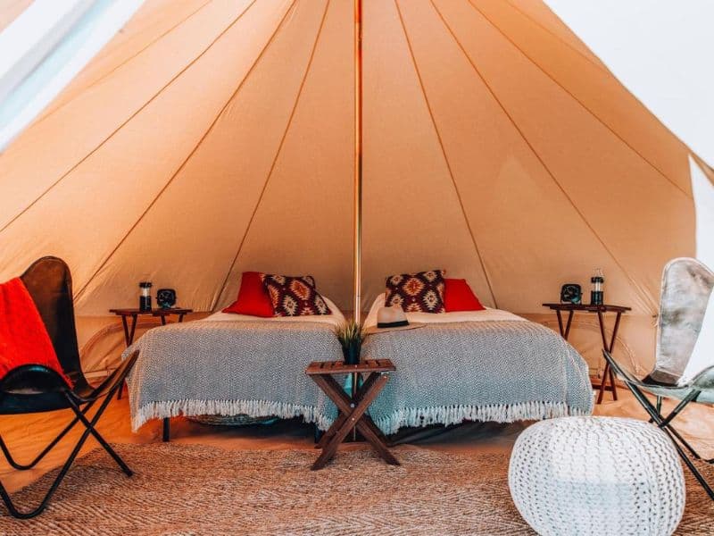 Cozy interior of a Wander Camp Grand Canyon tent with plush bedding and warm-toned accents.