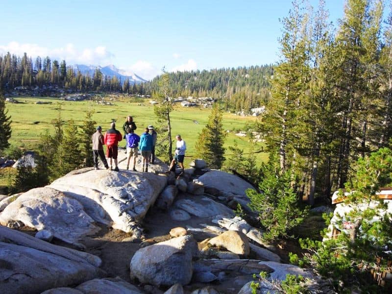 Group of hikers enjoying the panoramic views of Yosemite’s backcountry, near one of the High Sierra Camps.