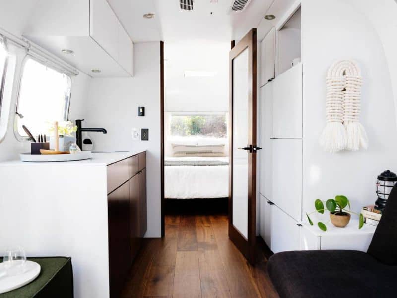 Modern and minimalist interior of an Airstream at AutoCamp Yosemite, with kitchenette and bedroom.