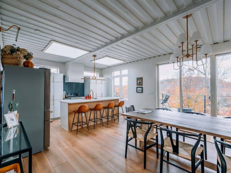 Modern kitchen with bar stools at The Overlook, a container cabin rental on Vrbo in Hocking Hills, showcasing a spacious area for dining and cooking.