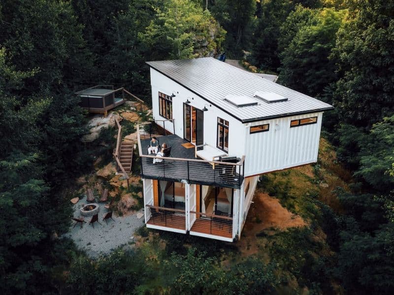 Aerial view of The Overlook set in a wooded area, highlighting the unique design of this Hocking Hills container cabin with its outdoor seating and multi-level decks.
