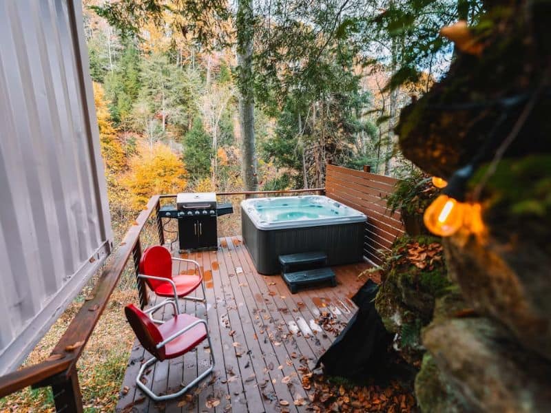 Outdoor deck of The Roca Box Hop with a hot tub and BBQ. Hocking Hills Container Cabin.