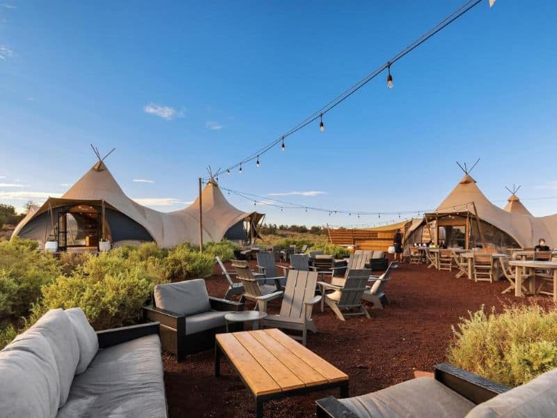 Under Canvas outdoor communal area with stylish seating lit with string lights near the Grand Canyon.