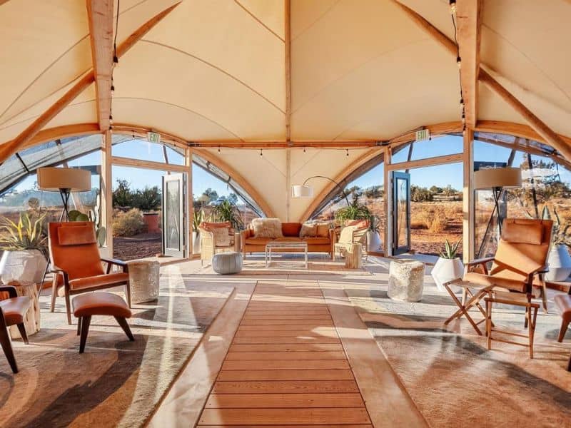 Spacious and elegantly furnished lounge area inside the Under Canvas Grand Canyon communal tent, with an open-air design.