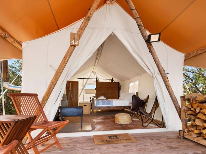 Well equipped Under Canvas Grand Canyon glamping tent with a view inside, complete with wooden furniture and a doormat.