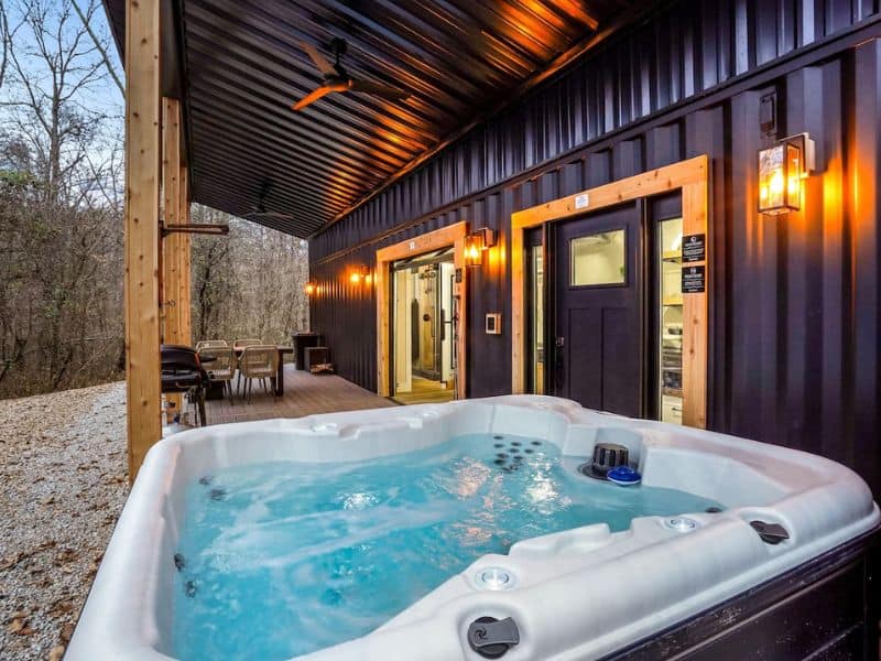 Hot tub on the covered patio of The Juice Box!, a unique Hocking Hills shipping container cabin.