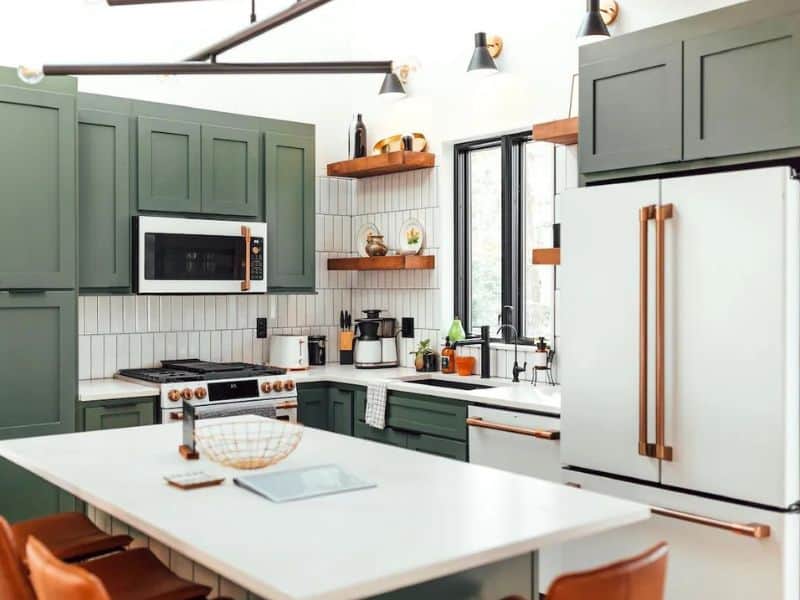 Sleek, green-themed kitchen with white countertops and retro appliances inside The Rohe Block container cabin in Hocking Hills.
