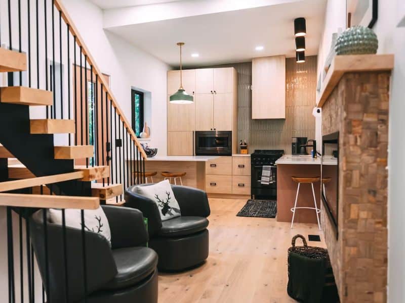 The interior of The Block Tower displays a staircase and lounge area adjacent to the kitchen. Container cabin in Hocking Hills.
