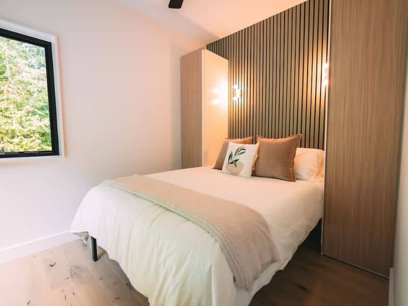 Minimalist bedroom with wooden accents at The Block Tower, a modern design Hocking Hills shipping container cabin.