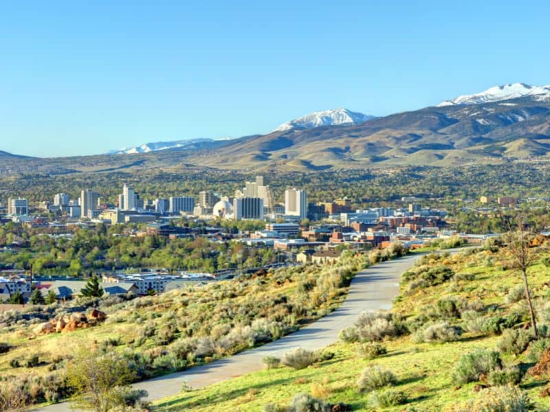 View of Reno, Nevada, with the cityscape set against the backdrop of snow-capped mountains.