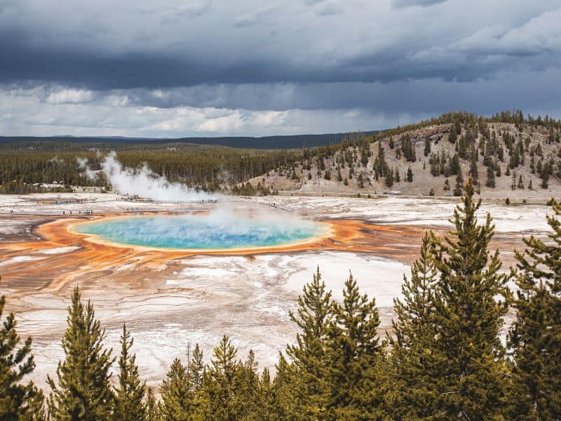 Overcast sky above Grand Prismatic Spring in Yellowstone National Park, showcasing the spring's striking colors and steam amidst the landscape.